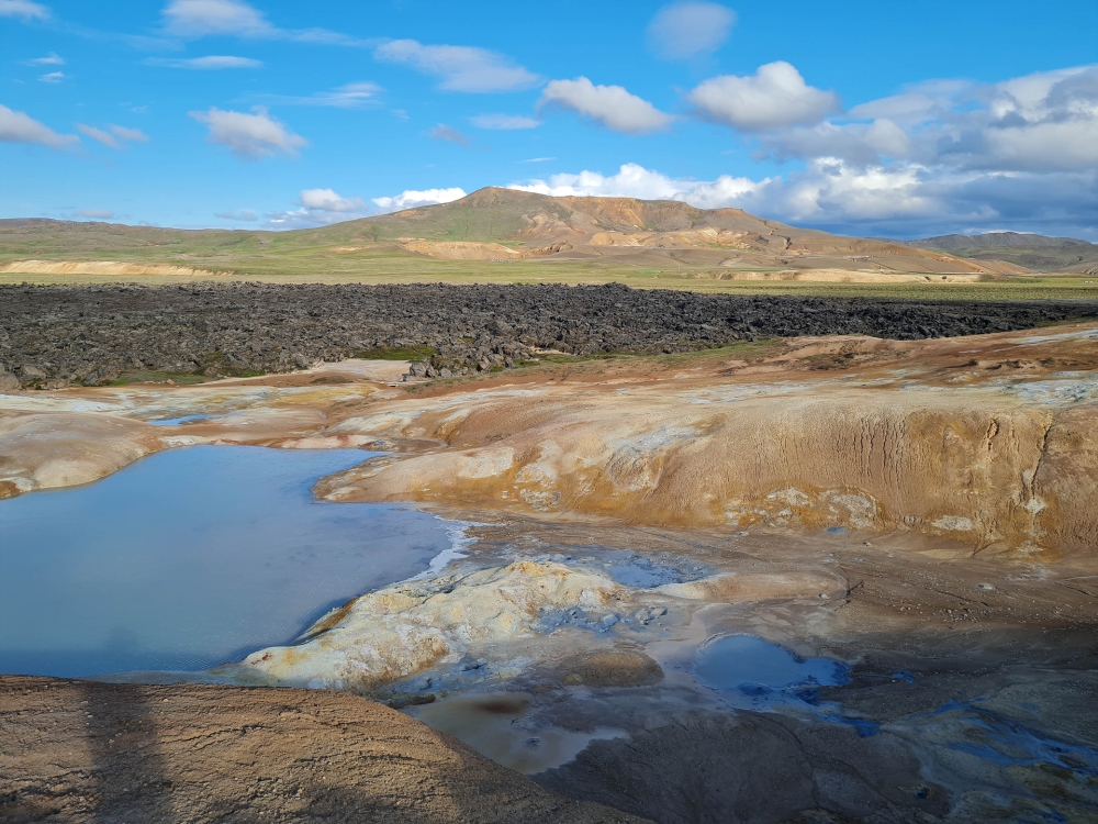 Solfataren und Schlammtöpfe am Leirhnjúkur, dahinter das Lavafeld und ganz hinten die Krafla (Nordostisland)