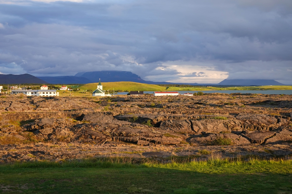 Blick vom Hlið-Camping über das Lavafeld zur Kirche von Reykjahlið am Mývatn (Nordostisland)